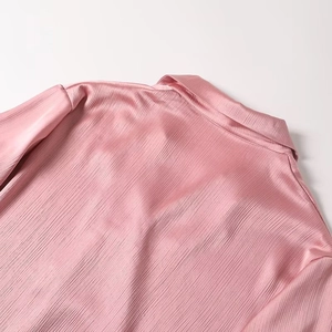 Detail of pink long sleeve shirt with pleated satin texture and soft glossy fabric