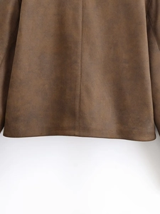 Macro detail of dark brown faux suede jacket hem showing clean stitching and matte texture