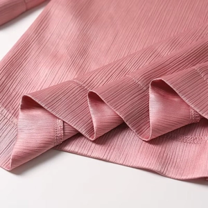 Close-up of pink mauve plissé pleated fabric texture and stitching details for women suits