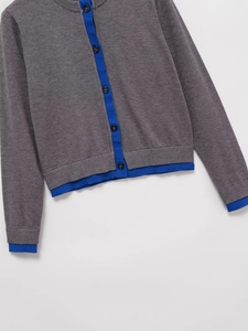 Detailed view of dark grey knit cardigan with blue trim and round neck on white background