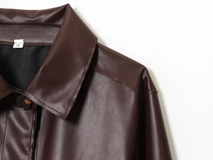 Détail du col d'une veste en simili cuir bordeaux, coutures et étiquette taille S
