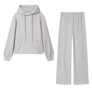 Détail d'un ensemble jogging gris à capuche montrant le coton doux et la grande poche