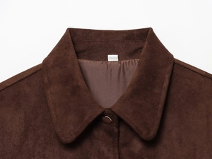 Detailed macro view of the brown suede jacket collar with satin lining and button closure