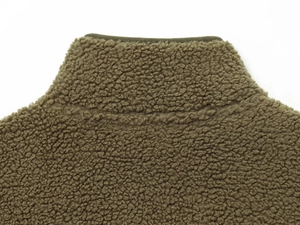 Vue macro détaillée du col montant en polaire teddy vert olive et texture épaisse