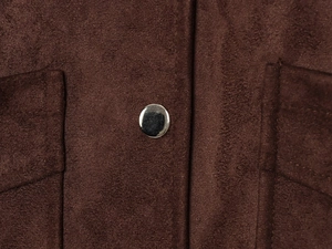 Detail of dark brown faux suede texture with silver metal snap button and stitching
