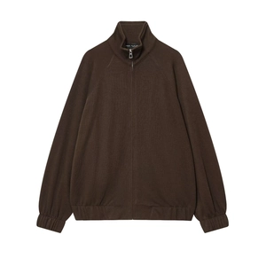 Detailed close-up of dark brown knitted jacket with metal zipper and ribbed high collar