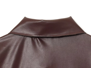 Gros plan du col en cuir PU bordeaux montrant la texture grainée et les coutures soignées