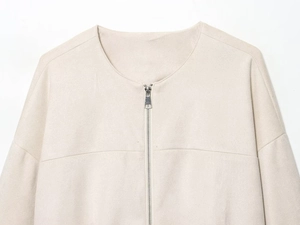 Détail d'une veste baseball en daim beige montrant le col rond et la fermeture éclair argentée