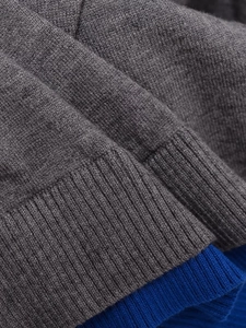 Detail of premium grey knit fabric and royal blue ribbed cuff on long sleeve cardigan