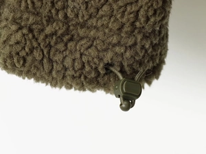 Gros plan sur le molleton teddy vert olive avec cordon de serrage et arrêt réglable