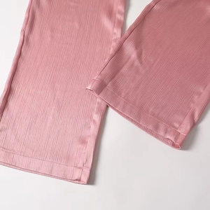Detail of pink pleated trousers hem with satin finish and high-quality stitching