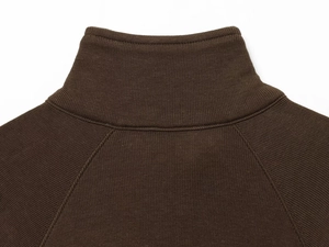 Detailed macro view of dark brown ribbed knit fabric and high-collar stitching on jacket