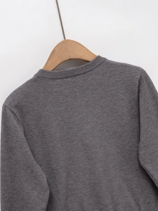 Detail of the crew neck collar and fine ribbed texture on the grey knit cardigan back