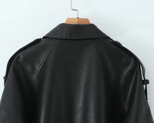 Macro view of the leather collar and shoulder epaulettes of a black PU biker jacket
