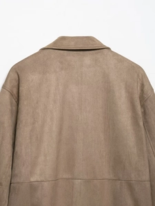 Macro shot of faux suede texture with back stitching detail on brown biker jacket