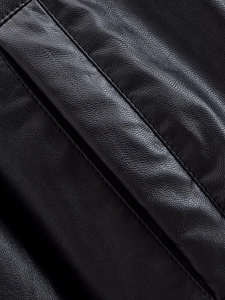 Detailed macro view of black faux leather texture with refined double stitching on jacket