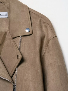 Detail of tan faux suede biker jacket featuring silver zippers and metallic snaps on collar