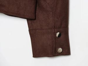 Detail of dark brown suede jacket cuff with silver metal snap buttons and neat stitching
