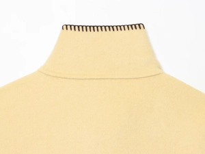 Detail of high collar faux wool jacket with contrast hand-stitched dark brown edging