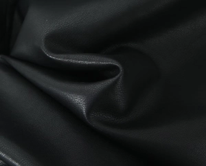 Close-up of black PU leather fabric showing high-quality lychee texture and matte finish