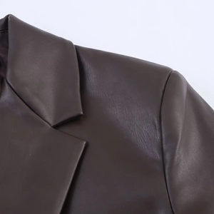 Close-up of deep brown PU leather blazer collar showing natural grain texture and seams