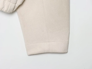 Vue détaillée du tissu beige texturé et des coutures d'une veste de baseball d'hiver