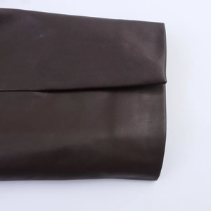 Detailed macro view of dark brown PU leather texture and premium stitched seams of the blazer