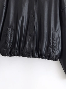 Detail of faux leather jacket featuring snap closure, side pockets and elastic hemline