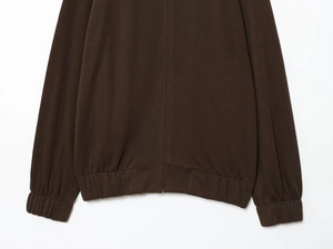 Detail of dark brown knit jacket with ribbed hem and cuffs texture on white background