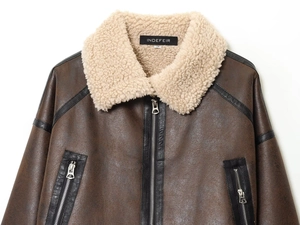 Detailed close-up of dark brown leather jacket collar with soft cream wool lining
