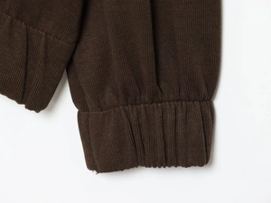 Macro shot of dark brown ribbed knit cuffs on a premium soft zip-up hoodie jacket