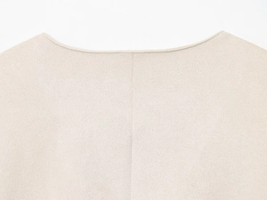 Vue détaillée du col d'une veste en maille beige avec coutures et texture de tissu précises