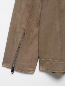 Detailed close-up of brown suede jacket sleeve with silver metal zipper and double stitching