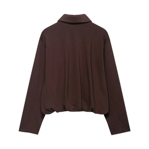 Detail view of the back of a brown velvet bomber jacket with elasticated pleated hemline