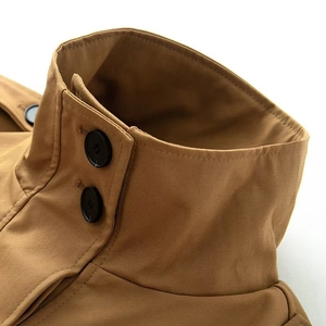 Gros plan du col montant d'un trench-coat kaki avec deux boutons noirs ronds