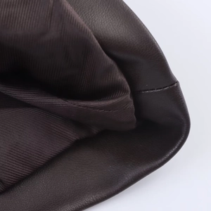 Detailed macro view of dark brown PU leather texture and premium inner lining stitching