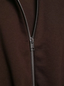 Detailed close-up of the silver metal zipper and brown velvet fabric on the bomber jacket