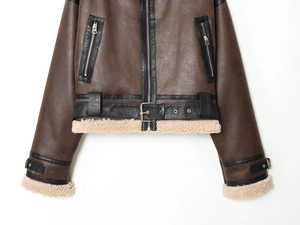 Detail of faux leather bomber jacket with silver metal zipper and cream sherpa lining