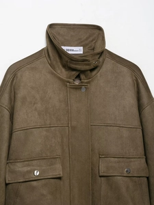 Détails de la veste bombardier en daim marron avec col montant et poches à boutons pressions
