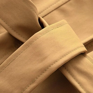 Gros plan du passant de ceinture de trench-coat kaki et de la texture du tissu sergé