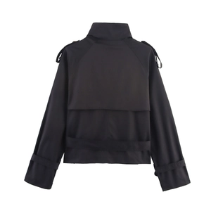 Detail of black short trench coat showing buttoned epaulets and classic back storm flap