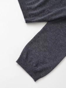 Detail of dark grey knit fabric with ribbed cuffs showing high-quality textile texture