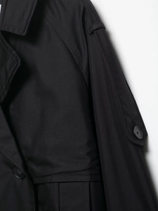 Détail de la texture du tissu et de la patte d'épaule avec bouton sur trench-coat noir
