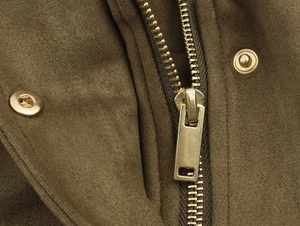 Dettaglio della zip in metallo dorato e bottoni a pressione su giacca in pelle scamosciata