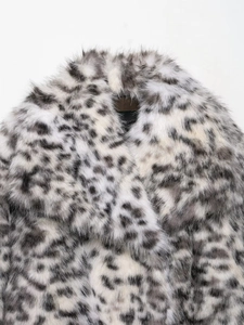 Detail of wide lapel on leopard print faux fur jacket with thick texture and gray tones