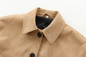 Detailed macro view of the khaki faux suede lapel collar and black button closure