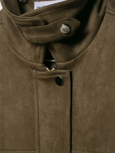 Vue macro du col de la veste bomber en daim olive avec boutons-pression en argent