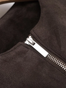 Dettaglio macro della zip metallica su giacca in pelle scamosciata marrone