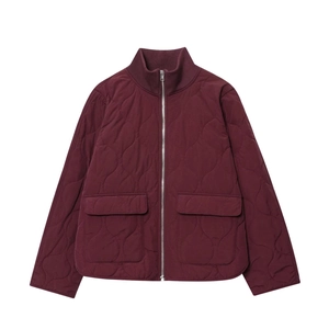 Detail view of burgundy quilted jacket showing ribbed stand collar and front cargo pockets