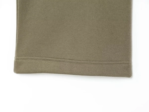 Gros plan détaillé montrant les coutures de précision et le tissu du jogging vert olive